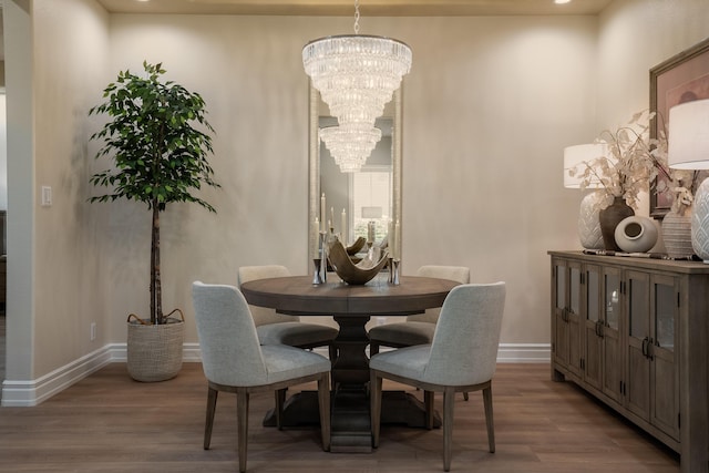 dining space featuring a notable chandelier, wood finished floors, and baseboards