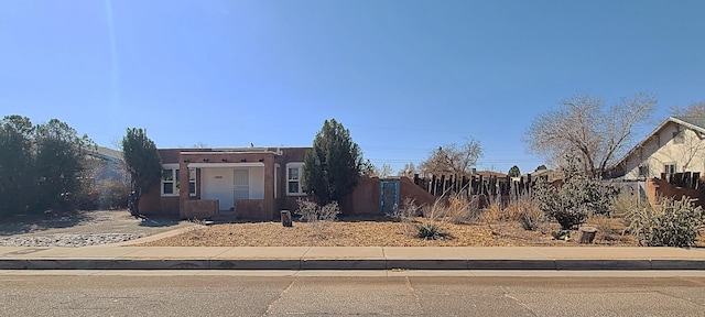 pueblo-style house featuring fence