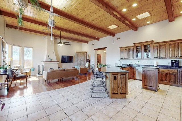 kitchen featuring dark countertops, light tile patterned floors, wooden ceiling, and a breakfast bar