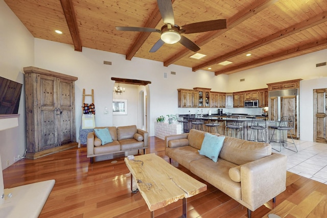 living room with beamed ceiling, wood ceiling, and light wood-type flooring