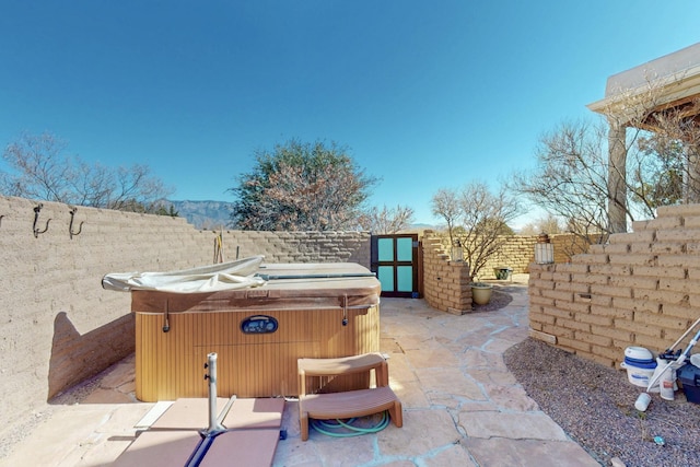 view of patio featuring a fenced backyard and a hot tub