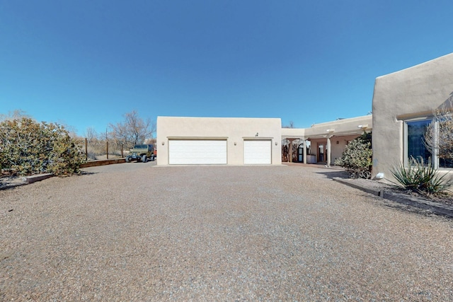 exterior space with gravel driveway and stucco siding