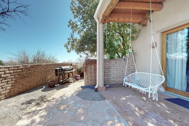 view of patio / terrace with a grill and fence