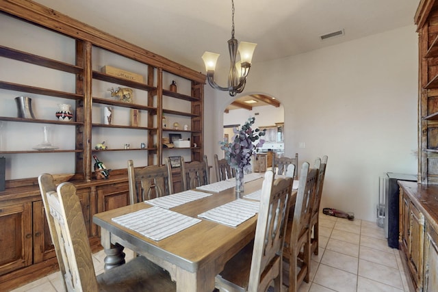 dining space featuring a notable chandelier, arched walkways, visible vents, and light tile patterned floors