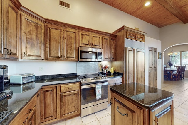 kitchen featuring visible vents, arched walkways, appliances with stainless steel finishes, wooden ceiling, and brown cabinetry