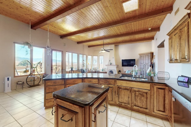 kitchen featuring a peninsula, brown cabinetry, dark countertops, and a sink