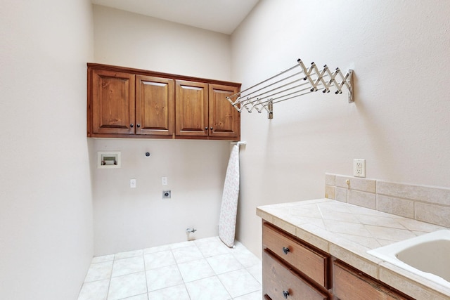 clothes washing area with washer hookup, a sink, hookup for a gas dryer, cabinet space, and hookup for an electric dryer