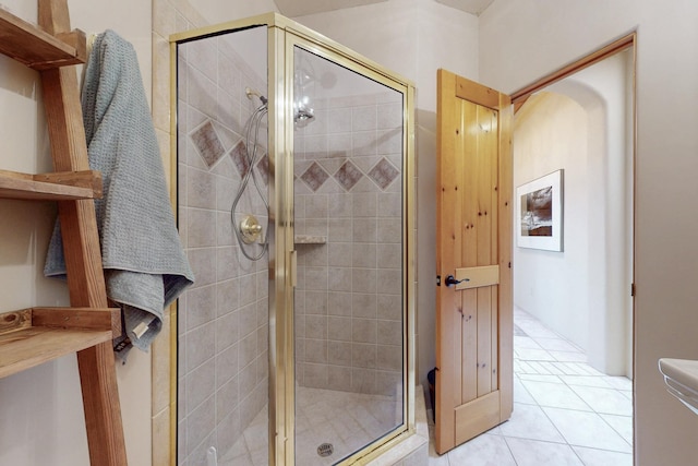 bathroom with a shower stall and tile patterned flooring