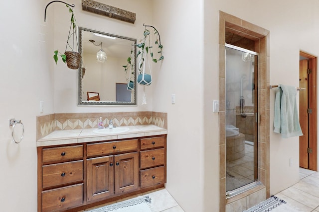 full bath featuring tile patterned floors, vanity, and a shower stall