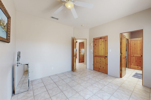 unfurnished bedroom featuring light tile patterned flooring, visible vents, and a ceiling fan