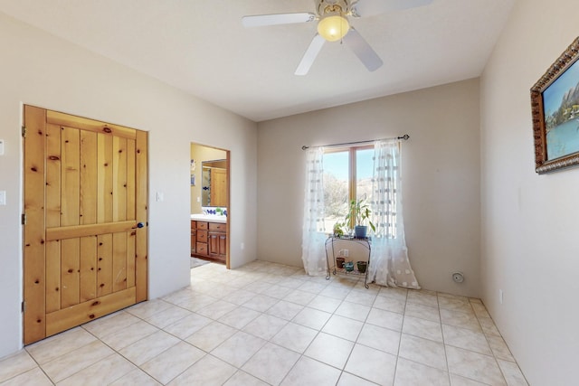 spare room with light tile patterned floors and a ceiling fan