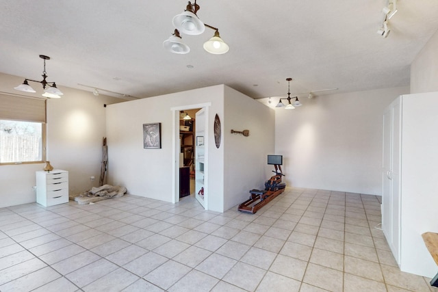 spare room with light tile patterned floors and rail lighting