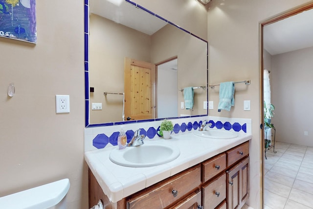 full bath featuring double vanity, toilet, and a sink