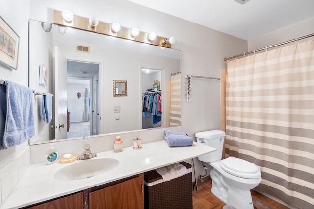 full bath featuring toilet, visible vents, and vanity