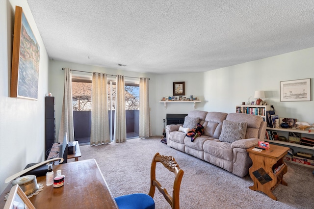 carpeted living area with visible vents, a fireplace, and a textured ceiling