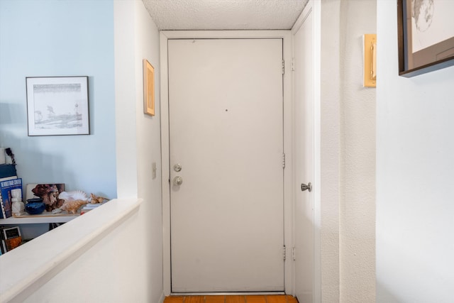 doorway featuring a textured ceiling