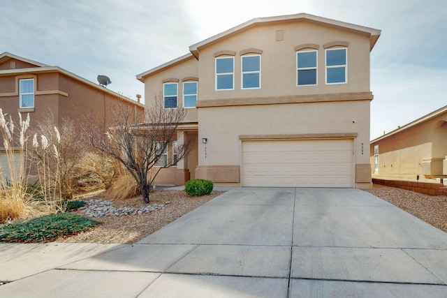 view of front facade featuring driveway, an attached garage, and stucco siding