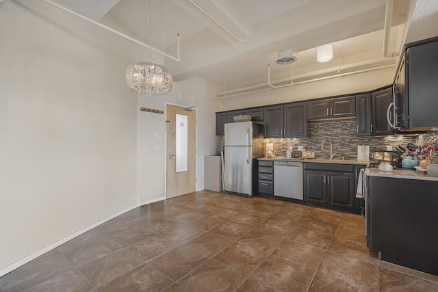 kitchen with stainless steel appliances, a sink, visible vents, light countertops, and backsplash