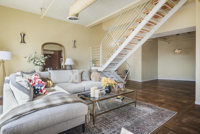 living area featuring visible vents, baseboards, and stairs