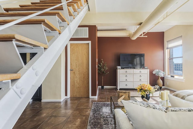 living room with stairway, baseboards, and visible vents