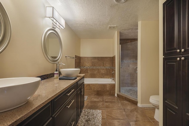 bathroom with a garden tub, visible vents, a sink, a textured ceiling, and tiled shower