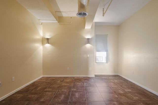 unfurnished room with tile patterned floors, visible vents, and baseboards