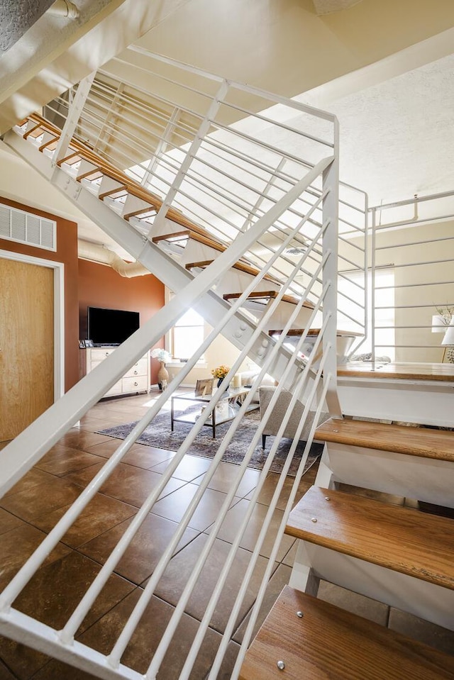 staircase featuring visible vents and tile patterned floors