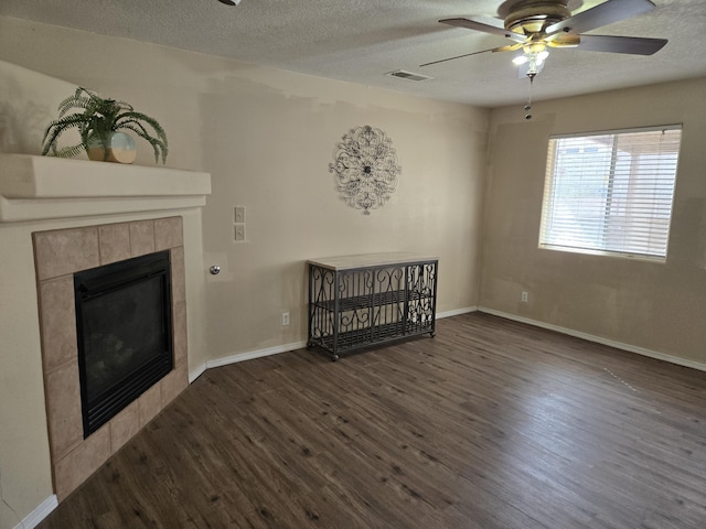 unfurnished living room featuring a textured ceiling, a fireplace, wood finished floors, and baseboards