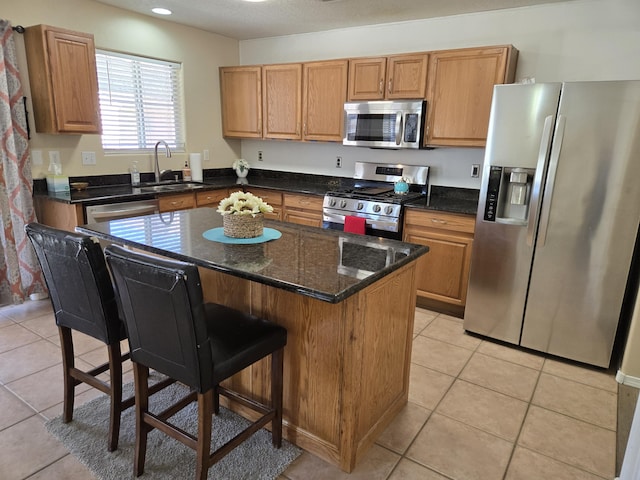 kitchen with stainless steel appliances, a breakfast bar, a sink, and light tile patterned floors