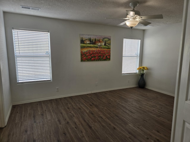 spare room featuring visible vents, ceiling fan, a textured ceiling, wood finished floors, and baseboards