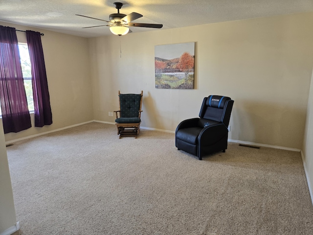 unfurnished room with a textured ceiling, carpet, visible vents, and baseboards