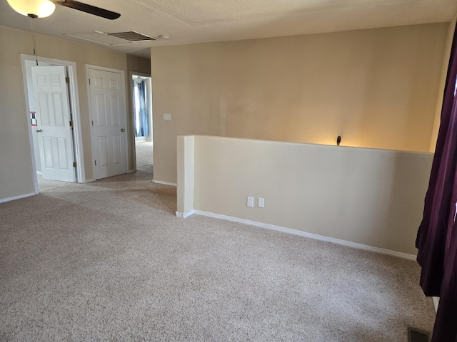 unfurnished room featuring baseboards, visible vents, and light colored carpet