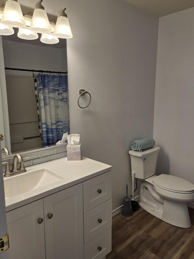 full bath with curtained shower, vanity, toilet, and wood finished floors