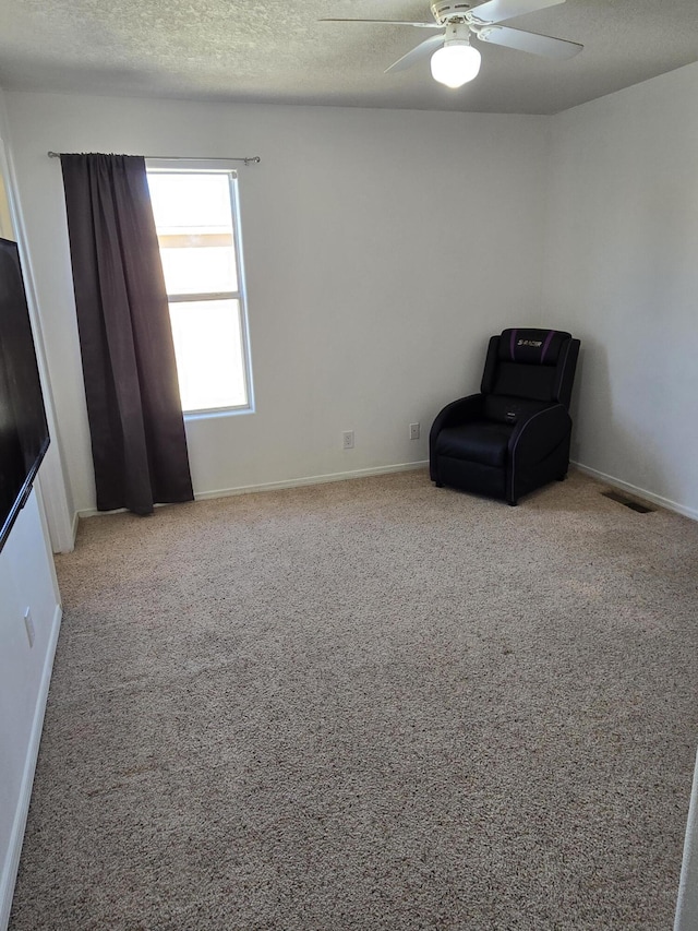 unfurnished room with visible vents, ceiling fan, a textured ceiling, and carpet flooring