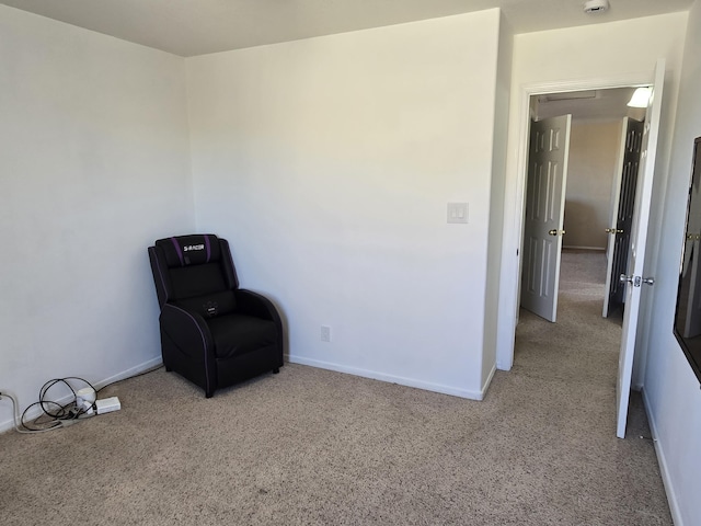 sitting room with baseboards and carpet flooring