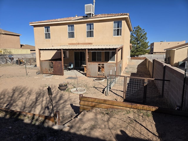 rear view of house with a fenced backyard, a patio, and stucco siding