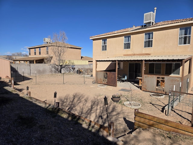 rear view of property featuring central air condition unit, a fenced backyard, a patio, and stucco siding