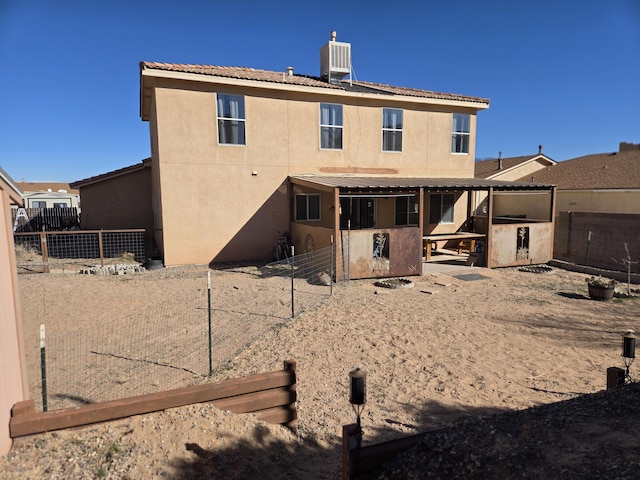 rear view of house featuring a patio, central air condition unit, a fenced backyard, and stucco siding