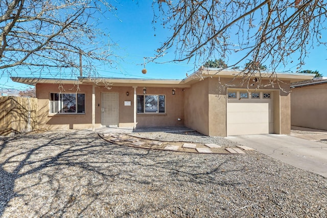 ranch-style house with an attached garage, driveway, and stucco siding