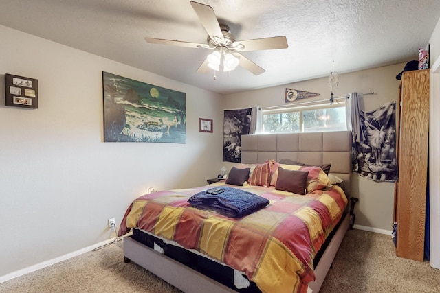 carpeted bedroom with a ceiling fan, a textured ceiling, and baseboards