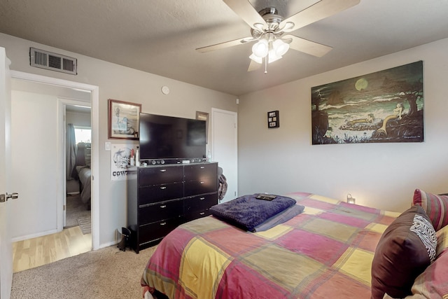 carpeted bedroom with visible vents, ceiling fan, and baseboards