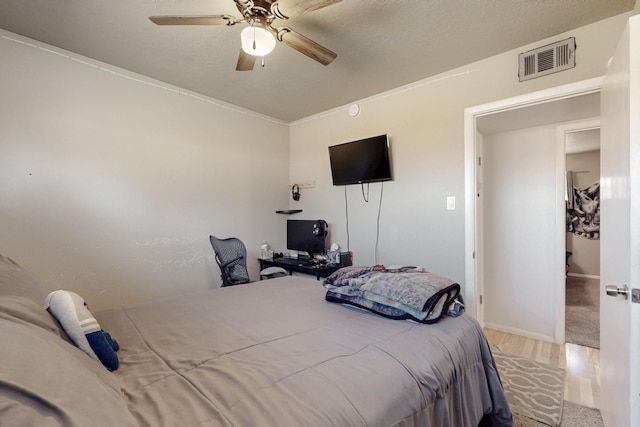 bedroom featuring visible vents, ceiling fan, and wood finished floors