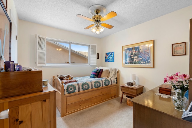 bedroom featuring light colored carpet, ceiling fan, and a textured ceiling