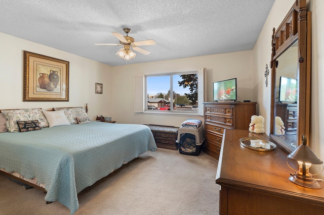 carpeted bedroom featuring a textured ceiling and a ceiling fan