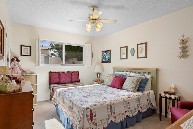 bedroom featuring a ceiling fan, light colored carpet, and a textured ceiling