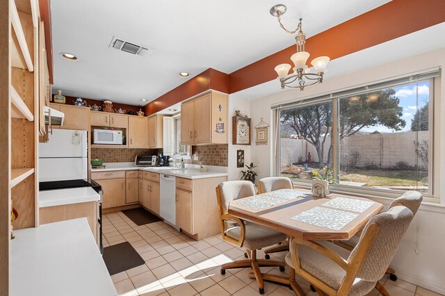 kitchen with light countertops, white appliances, and light brown cabinets