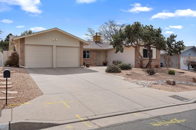 single story home featuring an attached garage, driveway, a chimney, and brick siding