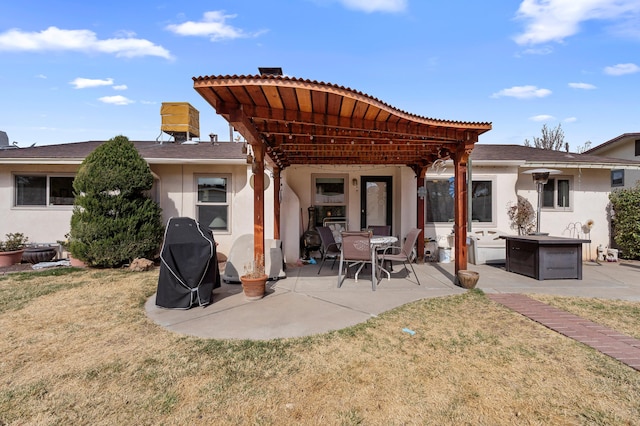 rear view of property with a lawn, a patio, and stucco siding