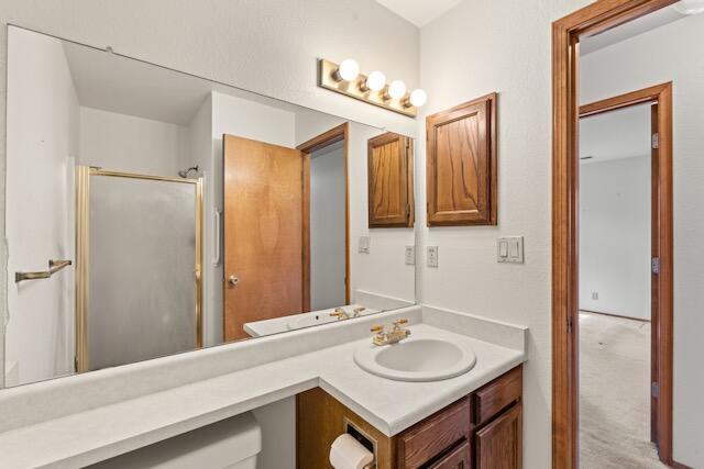 full bath with a stall shower and vanity