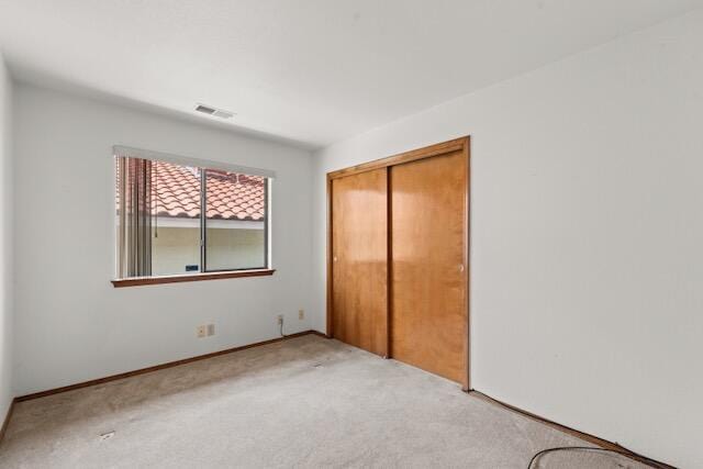 unfurnished bedroom featuring a closet, visible vents, and carpet floors